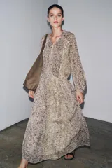 Vestido largo con estampado floral multicolor, cuello redondo con lazo ajustable, mangas largas abullonadas con puños elásticos y forro interior.