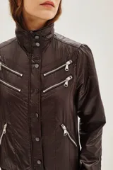Campera estilo biker color ciruela, con múltiples cierres metálicos decorativos en el frente y mangas. Tiene cuello alto con broches, puños y cintura elastizados.