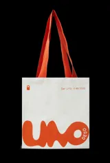 Bolso tipo tote bag color blanco con asas naranjas y estampado con el logo de la marca en naranja.