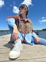 Camisa de manga larga con estampado animal print, mangas marrones y detalle celeste en la parte inferior.