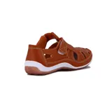 Guillermina casual de cuero color cognac, con diseño calado en la parte frontal y laterales, cierre de velcro en el empeine y suela plana blanca con base marrón.