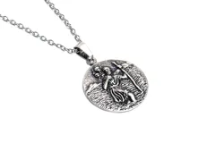 Collar con dije redondo plateado con la imagen de San Crist

óbal, santo patrono de los viajeros.