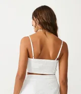 Blusa musculosa cropped blanca de laise texturizado con giro en el busto, tirantes finos ajustables y lastex en la espalda.