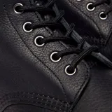 Botas de caña media Dr. Martens modelo 1460 Pascal, confeccionadas en cuero granulado negro. Presentan cierre mediante cordones, suela de goma con cámara de aire y el característico pespunte amarillo en el borde.