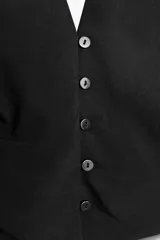 Top negro con cuello halter, escote pico y espalda descubierta. Presenta detalle de frunces laterales y cierre frontal con botones.