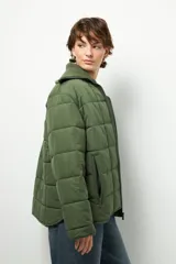 Campera marrón capitoneada de manga larga con cuello alto de tela, cierre frontal y bolsillos laterales con cierre.