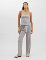 Set de pijama de tres piezas en color verde menta con estampado floral sutil, compuesto por una camisa de manga corta con botones, una musculosa básica y un pantalón largo de corte recto con cordón ajustable en la cintura.