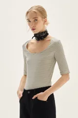 Remera de manga tres cuartos, corte ajustado al cuerpo, con escote redondo amplio. Presenta un patrón de rayas finas horizontales en tonos azul marino y blanco.