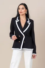 Blazer negro cruzado con vivos blancos, botones dorados, bolsillos delanteros y detalle de cuatro botones dorados en las mangas.