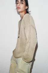 Jersey de punto de manga larga y cuello barco, con diseño holgado y acabado texturizado.