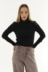 Polera blanca de algodón con cuello alto cruzado y mangas largas.