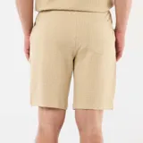 Bermuda de punto grueso color beige, de diseño liso, con bolsillos laterales y cintura elástica.