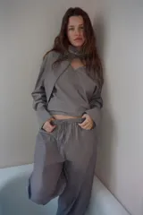 Camisa de algodón con diseño a rayas verticales, escote en pico con detalle de pañuelo ajustable mediante lazada, manga larga con puños abotonados y aberturas laterales en el bajo.