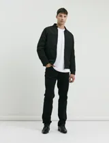 Pantalón de corte recto y estilo clásico, confeccionado en sarga de algodón con elastano. Presenta diseño de cinco bolsillos, cierre frontal con botones metálicos y bolsillos traseros de parche.