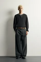 Camiseta relaxed fit de punto negro tejido en hilatura de algodón, con cuello redondo, cierre frontal de botonadura y manga larga con acabado en rib.