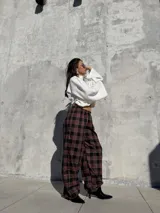 Pantalón de viyela con estampado a cuadros en tonos bordó y negro. Presenta un diseño de silueta amplia con cintura elástica y puños ajustados en los tobillos.