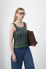 Top tejido sin mangas con diseño geométrico de rombos en relieve, en tonos azul marino y beige. Presenta escote amplio y breteles tejidos.