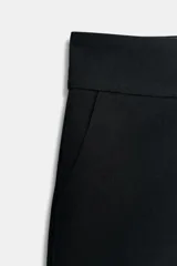 Shorts de tiro medio color crema, con bolsillos laterales y falsos bolsillos con solapa en la parte trasera. Cierre frontal con cremallera y ganchos metálicos.