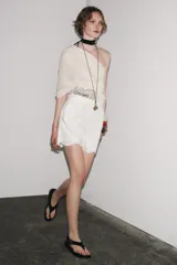 Bermuda negra de tiro alto confeccionada en hilatura de algodón con bordados perforados a tono, forro interior y cierre con cremallera oculta en costura.