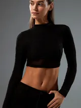 Top negro con cuello alto, mangas largas de tul y corte crop.