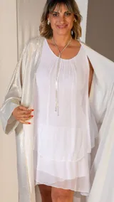 Conjunto de bijouterie plateado con collar de cadena fina y dije de strass con forma de lágrima, y aros colgantes con strass.