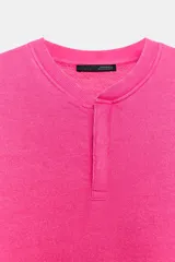 Sudadera fucsia con efecto lavado, confeccionada en mezcla de algodón. Cuenta con cuello redondo con una pequeña abertura frontal con botones, manga larga caída y puños y dobladillo en rib.