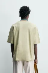 Camiseta boxy fit color verde militar con efecto lavado, confeccionada en tejido compacto de algodón, con cuello redondo y manga corta.