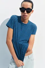 Camiseta de corte slim fit y diseño a rayas horizontales, con cuello redondo y mangas cortas.