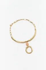 Collar dorado con cadena de eslabones y dije colgante con forma orgánica y piedra rosada.