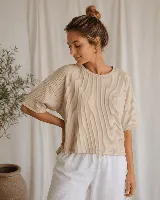 Remera de morley color beige, con cuello redondo, mangas cortas y corte holgado.