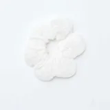 Coletero de tela blanca con diseño bordado tipo broderie, con elástico interno para sujetar el cabello.