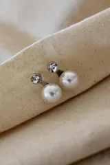 Par de aros plateados con perlas blancas y strass.
