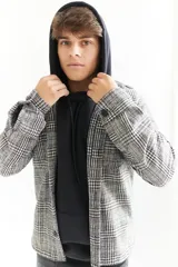 Sobrecamisa escocesa de paño en tonos blanco, negro y marrón. Corte recto con cuello camisero, cierre frontal con botones, dos bolsillos de parche en el pecho y puños abotonados. Disponible en tallas S a XL.