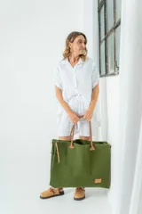 Bolso grande de fieltro color verde oliva con asas de cuero marrón.