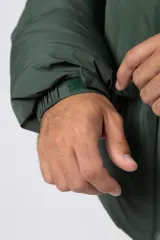 Campera puffer de corte relajado en color verde oscuro, con cuello alto, cierre frontal completo y logo bordado en el pecho.