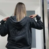 Campera con capucha y cierre frontal Eseele, modelo Eseele Club Stone, con acabado stonewash de efecto desgastado en color gris carbón, bolsillos delanteros y logo ovalado retro en la espalda.