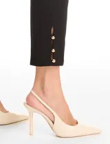 Pantalón tipo pull-on de gabardina elastizada, color negro, con pretina ancha y detalle de botones en el ruedo.