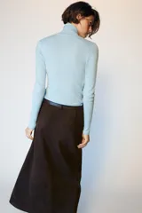 Jersey de punto celeste con cuello subido y manga larga, confeccionado con mezcla de lana.