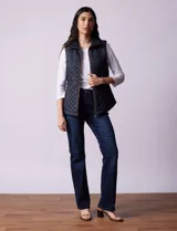 Chaleco capitoneado color beige, marca Gallery. Con abertura central con cierre, bolsillos delanteros con cierre, laterales en tejido elastizado y forro interno a tono.