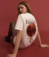 Remera blanca de algodón con cuello redondo y mangas cortas. Estampa trasera con la frase "Challenge Yourself", una pelota de baloncesto y estrellas.