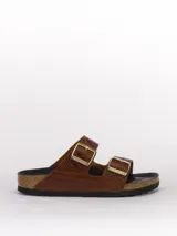 Sandalias Birkenstock Arizona color marrón con estampado de piel de reptil y hebillas doradas.
