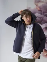 Campera verde oscuro con capucha, cierre frontal y bolsillos laterales.