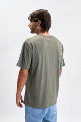 Remera de manga corta con corte oversize, color verde oliva, con estampa pequeña en el pecho con la frase 'gettin ready'.