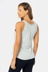 Musculosa blanca sin mangas, de corte clásico y calce cómodo, confeccionada en tejido suave. Presenta escote redondo, cartera con botones frontales y un pequeño bolsillo aplicado en el pecho.