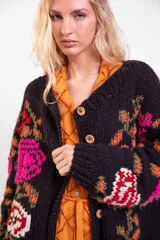 Cardigan de lana merino tejido y bordado a mano de calce holgado con cuello a la base, mangas largas y cierre frontal de botones. Presenta un diseño artesanal con bordados coloridos en las mangas y el cuerpo.