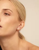 Aro piercing plateado con forma circular y una perla blanca en el centro.
