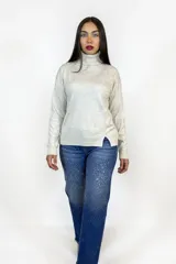 Polera de cuello alto en color beige, confeccionada en tejido de punto suave, con corte recto y detalle de tajo lateral en el ruedo.