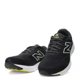 Championes de running New Balance Evoz Fresh Foam para hombre, color negro con entresuela blanca y suela negra con detalles amarillos. Presentan el logotipo 'N' en los laterales en color verde claro y tecnología Fresh Foam en la entresuela para mayor amortiguación.