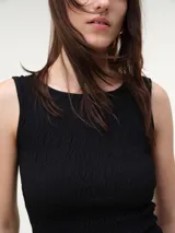 Musculosa de algodón color negro con escote bote, diseño con nido de abeja elástico y terminación con pequeño vuelo en el ruedo.