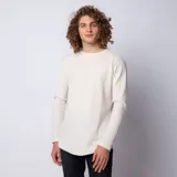 Buzo de manga larga con cuello redondo, confeccionado en tela tipo waffle de color beige. Presenta un corte long-fit con ruedo redondeado, ofreciendo un estilo relajado y moderno.